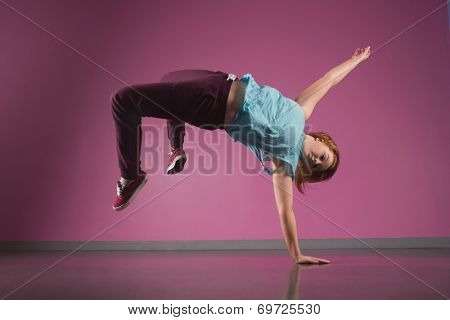 Pretty break dancer doing a handstand in the dance studio