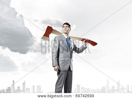 Young determined businessman with axe on shoulder