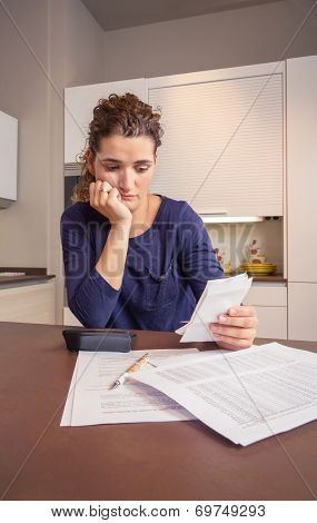 Unemployed and divorced woman with debts reviewing her monthly bills