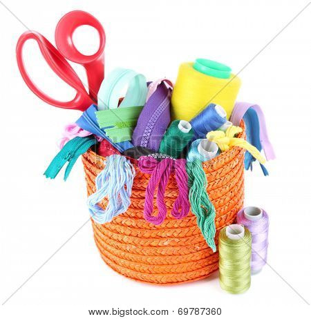 Round orange box full of multicoloured threads and everything necessary for sewing on white background isolated