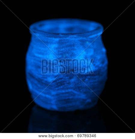 Candlestick painted fluorescent paint isolated on black