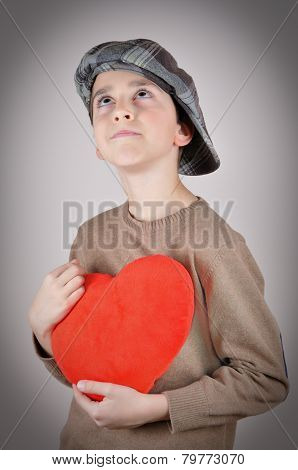 Young boy holding a plush red heart