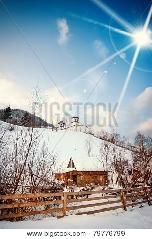 View of Romanian small church on hill covered with snow. Winter landscape with orthodox church