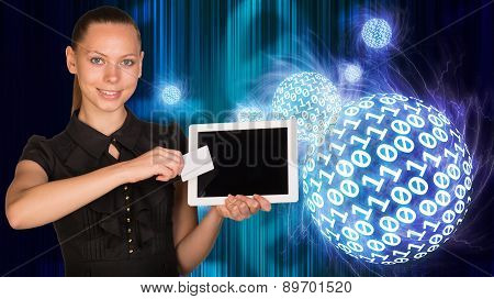Smiling young woman holging tablet and card