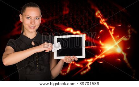 Smiling young woman holging tablet and card