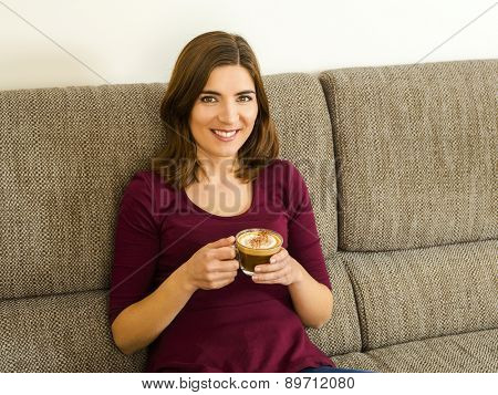 Beautiful woman at home drinking a capuchino