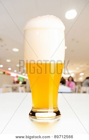 glass of fresh draft unfiltered beer on table in cafe