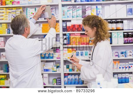 Pharmacists searching medicines with prescription at hospital pharmacy