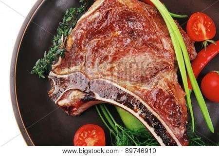 meat food : grilled beef spare rib on dark dish with thyme pepper and tomato isolated over white background