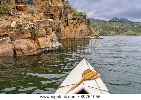 canoe and sandstone cliff - springtime paddling Horsetooth Reservoir near Fort Collins, Colorado