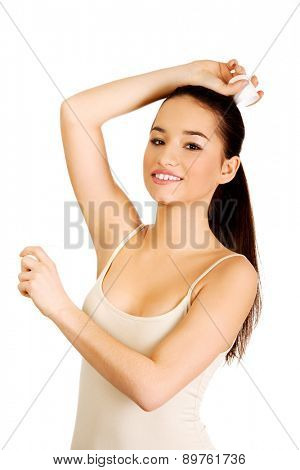 Young smiling woman applying anti perspirant.