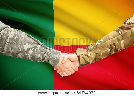 Men In Uniform Shaking Hands With Flag On Background - Benin
