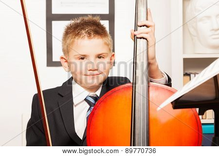 Smiling boy holding fiddlestick, play violoncello