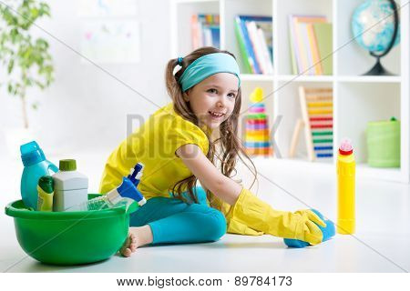 Cute little girl cleanses a floor