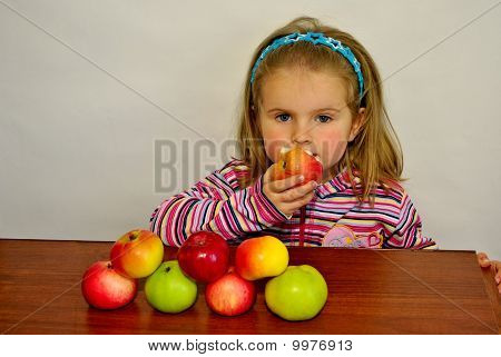 Das Mädchen isst einen Apfel