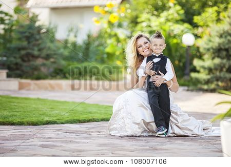 Happy bride and smiling little boy outdoors