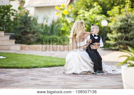 Happy bride and smiling little boy outdoors