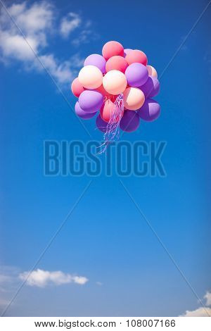 Bunch of purple and pink balloons in the sk
