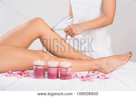 Young Woman Getting Laser Treatment On Leg At Spa