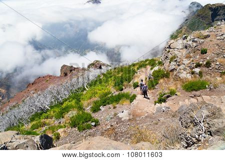 Tourists On Madeira Go On A Stony Track Highly In Mountains, On An Equal Basis With Clouds