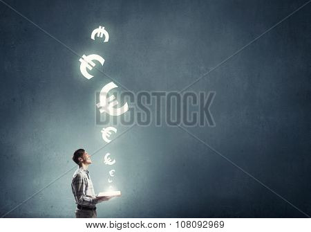Young man in casual holding opened book with euro sign