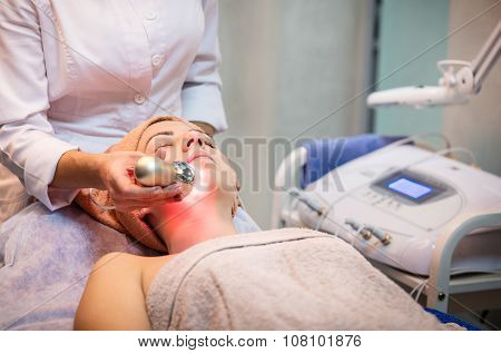 Young woman receiving facial treatment.