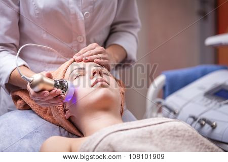 Young woman receiving facial treatment.