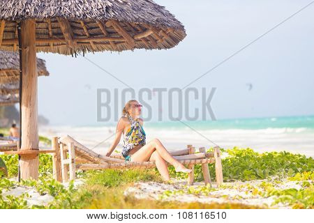 Woman sunbathing on tropical beach.