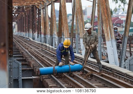Asian bridge builders working on old vintage Long Bien bridge