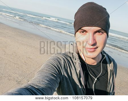 Young Handsome Guy With Male Sport Clothes Taking Selfie On The Beach In Autumn Season -  Healthy An