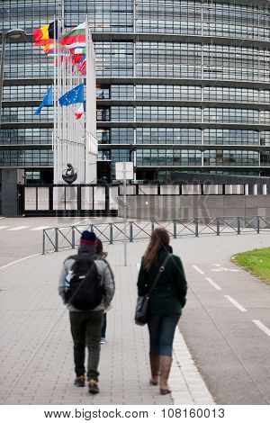 STRASBOURG FRANCE - 14 Nov 2015: Tourists admiring as European Union Flags and France flag flies at half-mast in front of the European Parliament building following an terrorist attack in Paris