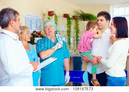 Exhausted Medical Staff Announcing Good News To Relatives After Long And Difficult Surgery