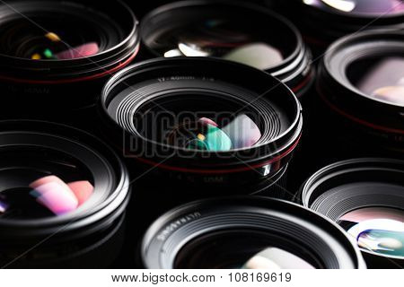 Modern camera lenses with reflections, low key image