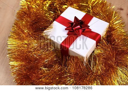 New Year gift on a golden tinsel background boly