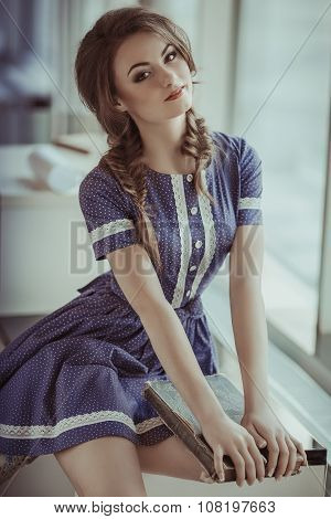 Young girl with old books in vintage dress