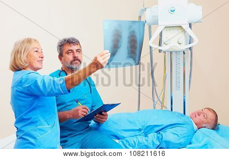 Doctors Discussing The Roentgen Radiogram In  X-ray Room With Patient