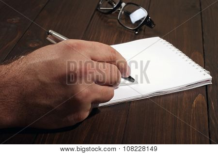 Man Writes In A Notebook