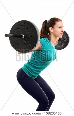 Beautiful fit young girl with barbell doing squats, isolated on white background.