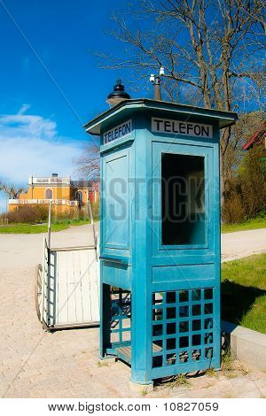 Antikke telefonboks og en vogn
