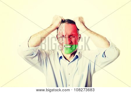 Angry mature man with Bealrus flag painted on face.