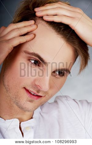 Young handsome man is worried about hair loss.