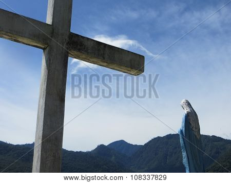 Cross and Mary in front of mountains