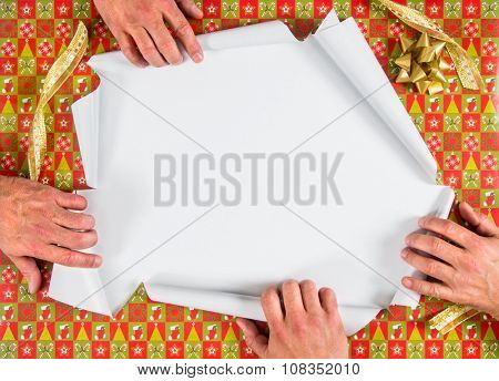 Christmas wrapped present being ripped open by four hands