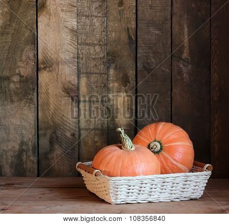 Pumpkins In A Basket On A Wooden Background.