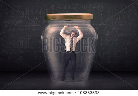 Business man closed into a glass jar concept on background