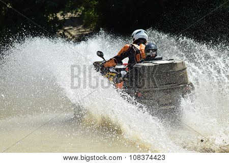 The Man On The Atv Crosses A Stream