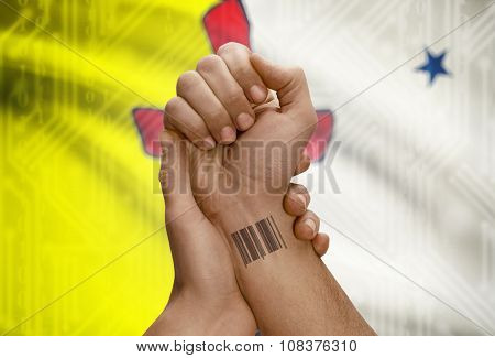 Barcode Id Number On Wrist Of Dark Skin Person And Canadian Province Flag On Background - Nunavut
