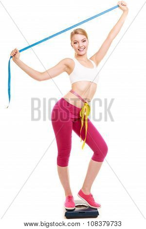 Woman Measuring On Weighing Scale With Raised Arms