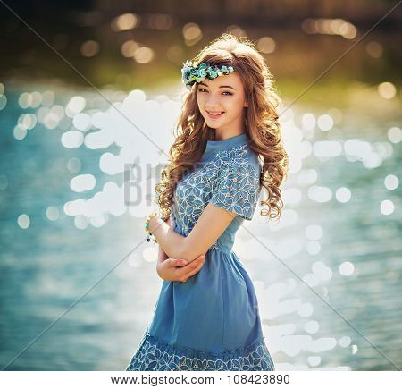 Beautiful young girl in a light sundress near the river