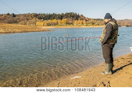 Senior fisherman fishes in Solina Lake, Bieszczady, Poland